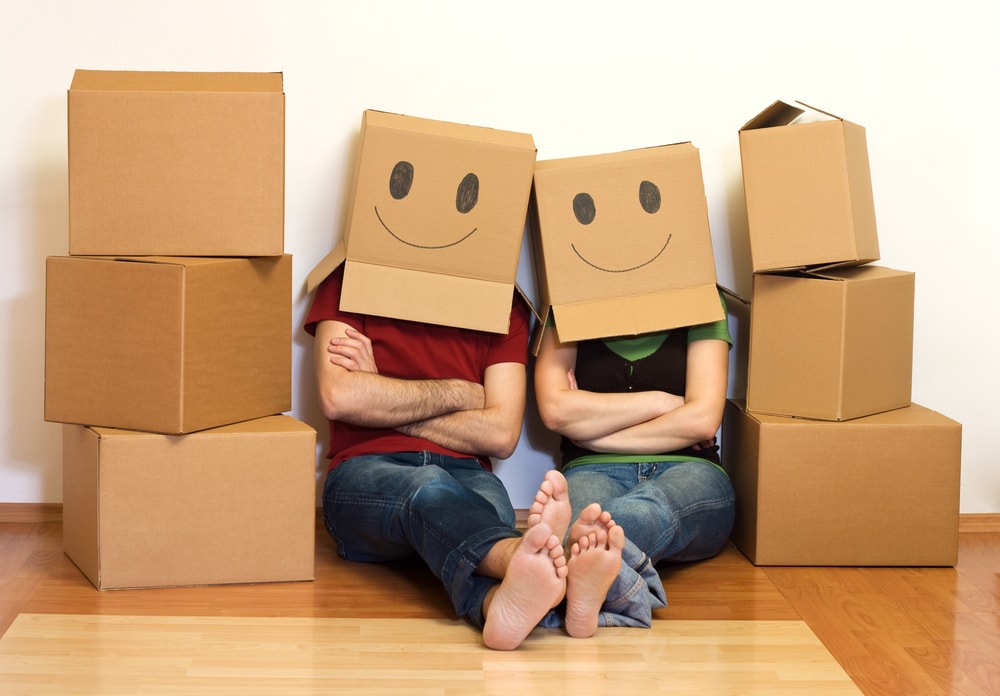 couple with moving boxes on head