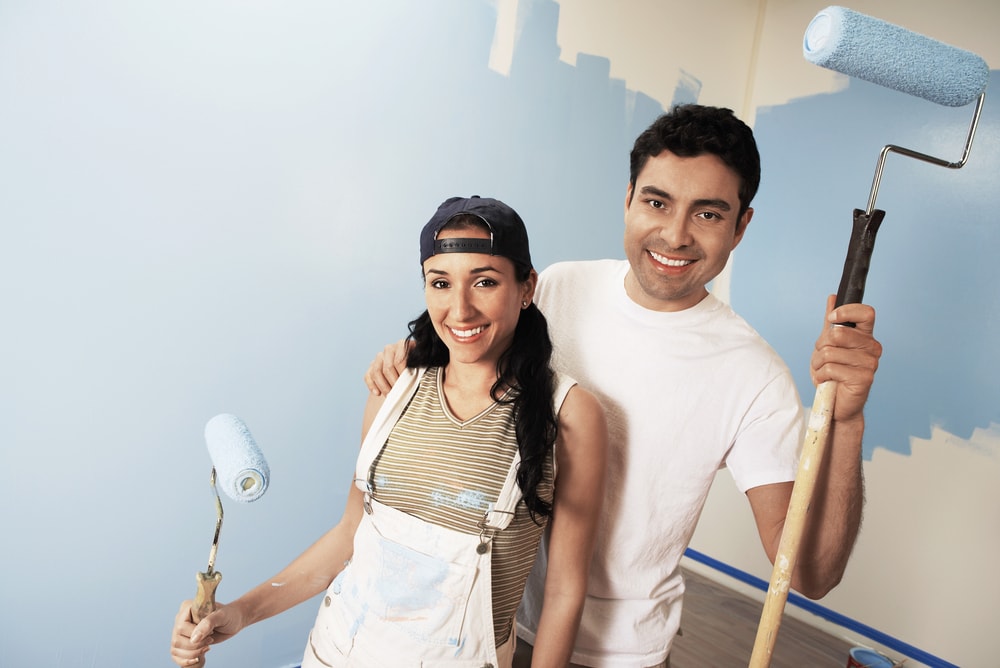 couple painting home blue