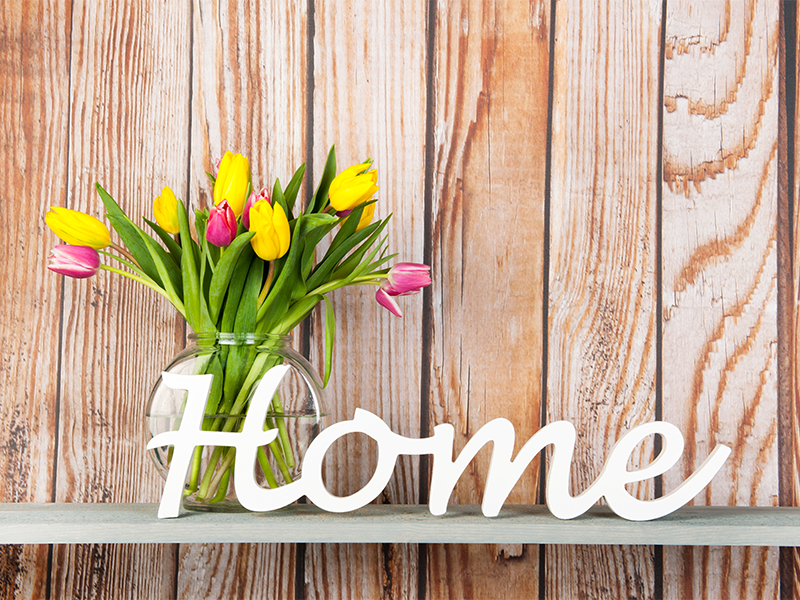 "home" written in wood next to flowers