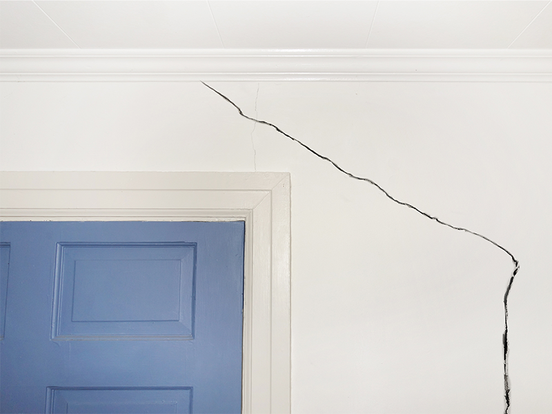 close up of crack in wall going above the door